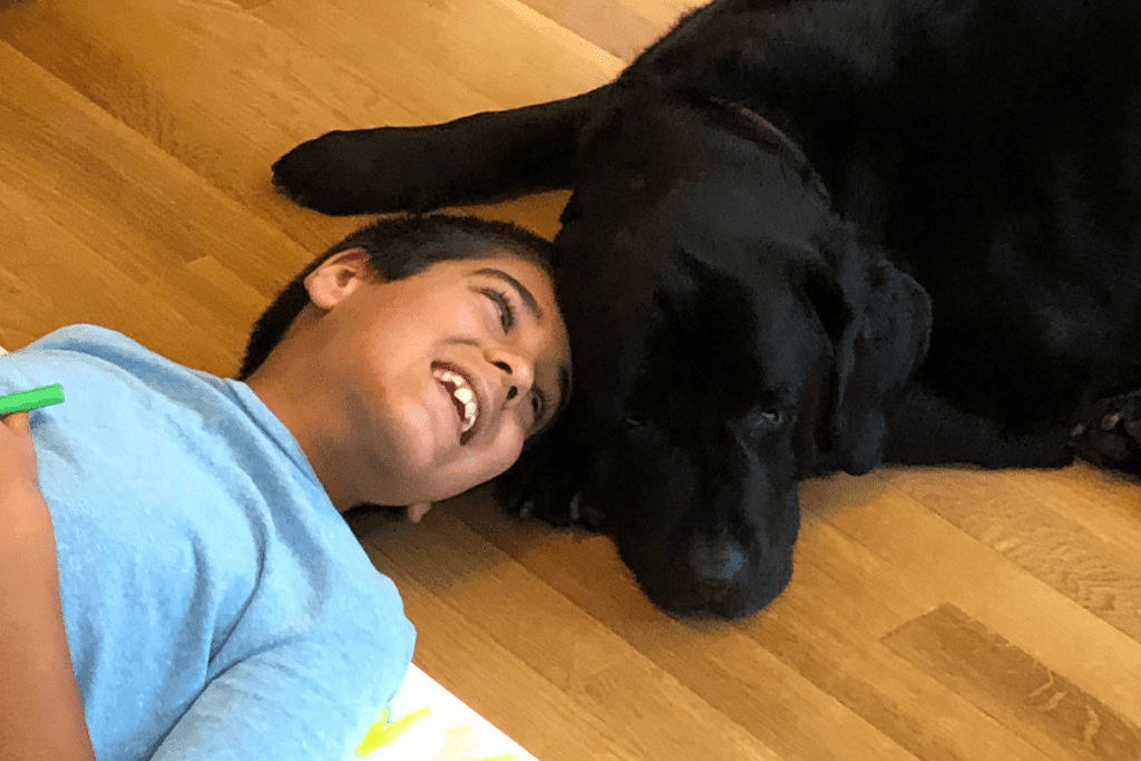 kid and labrador lying on floor together