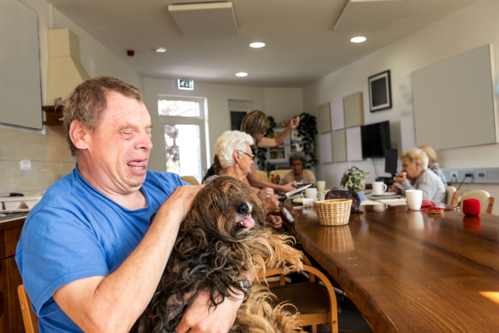 man petting therapy dog